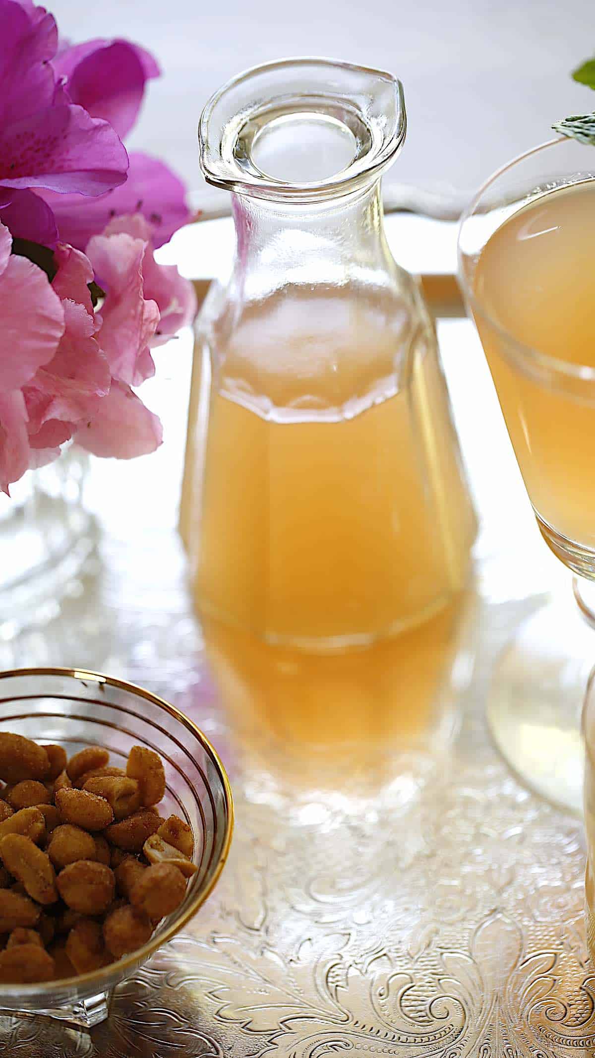 a tiny glass pitcher of grapefruit syrup on a tray