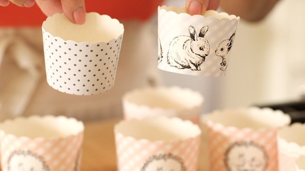 A person holding cupcake liners showing the design