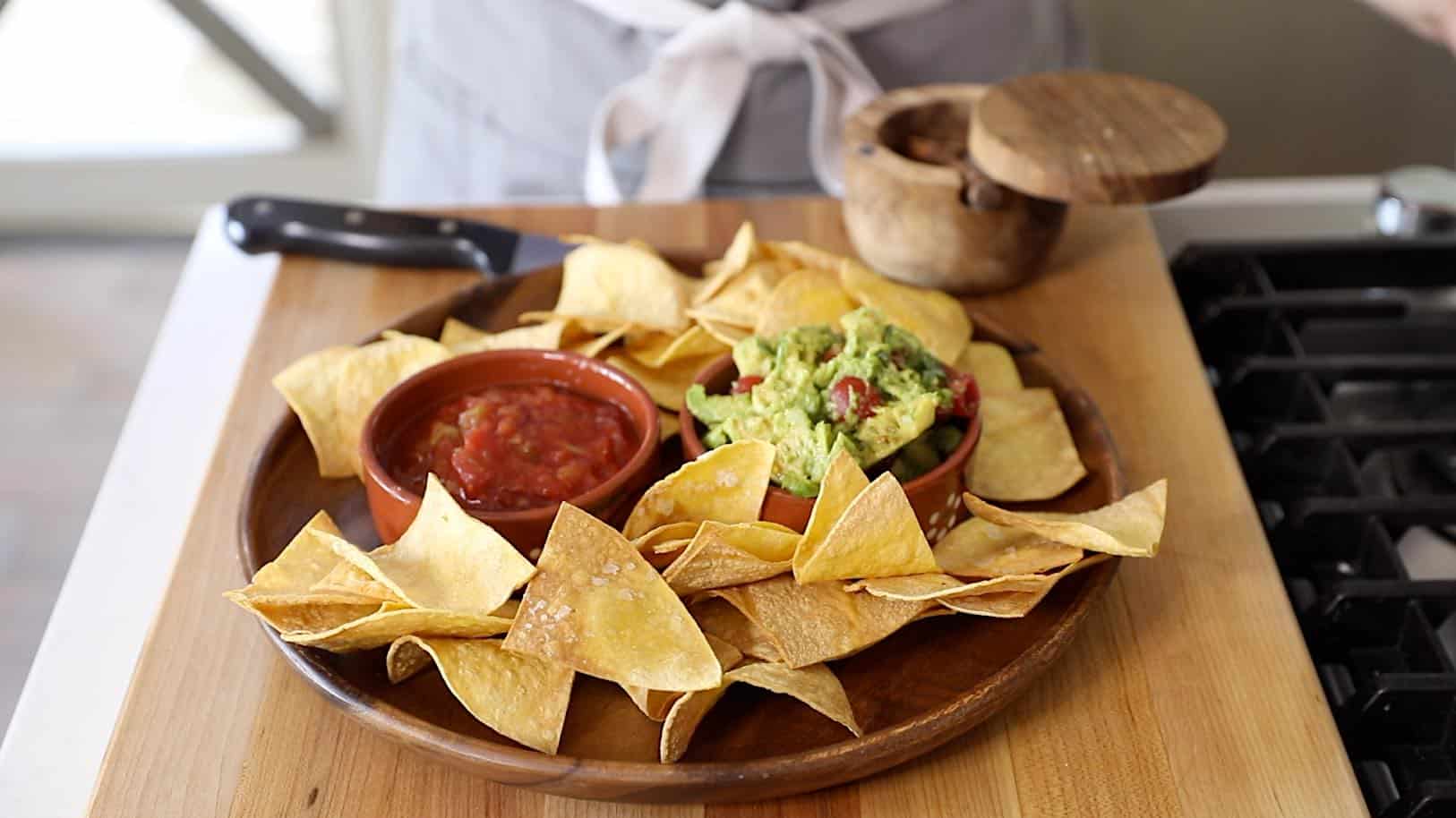 a platter of tortilla chips with guacamole and salsa