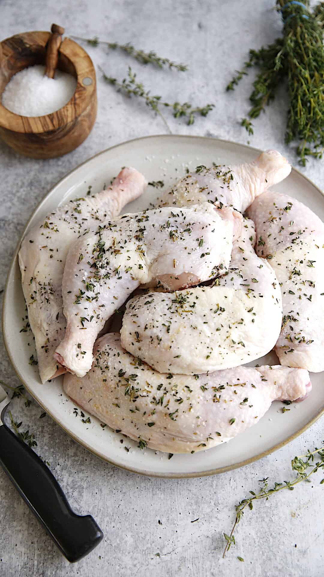 Raw chicken legs seasoned with Thyme and Salt on a plate