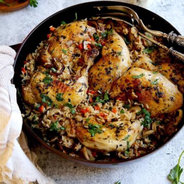 One Pot Chicken and Rice on a counter with silver serving pieces