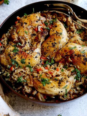 One Pot Chicken and Rice on a counter with silver serving pieces