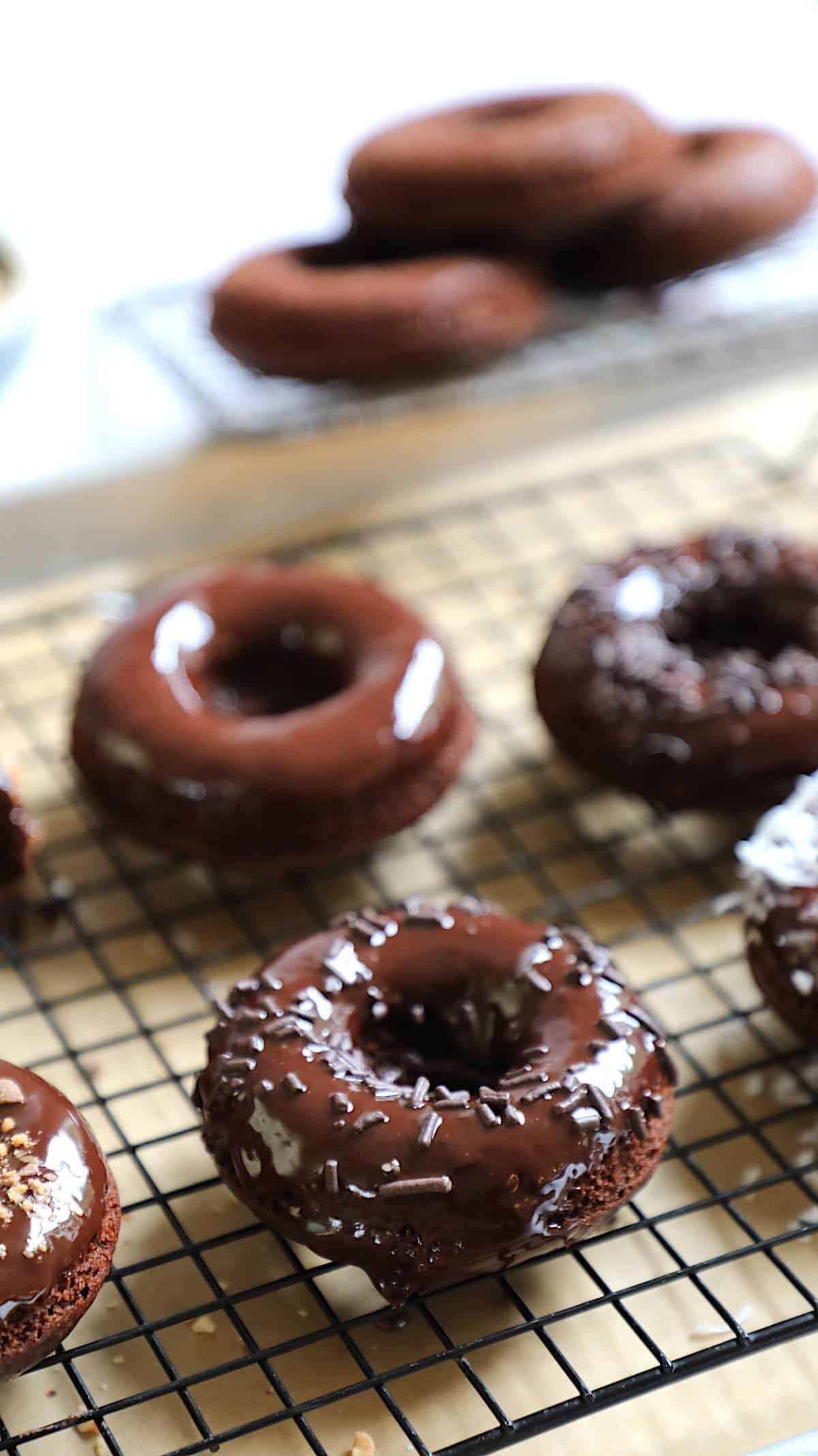 Vertical Image of Chocolate donuts on a cooling rack