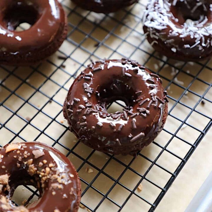 a chocolate donut with ganache and chocolate sprinkles