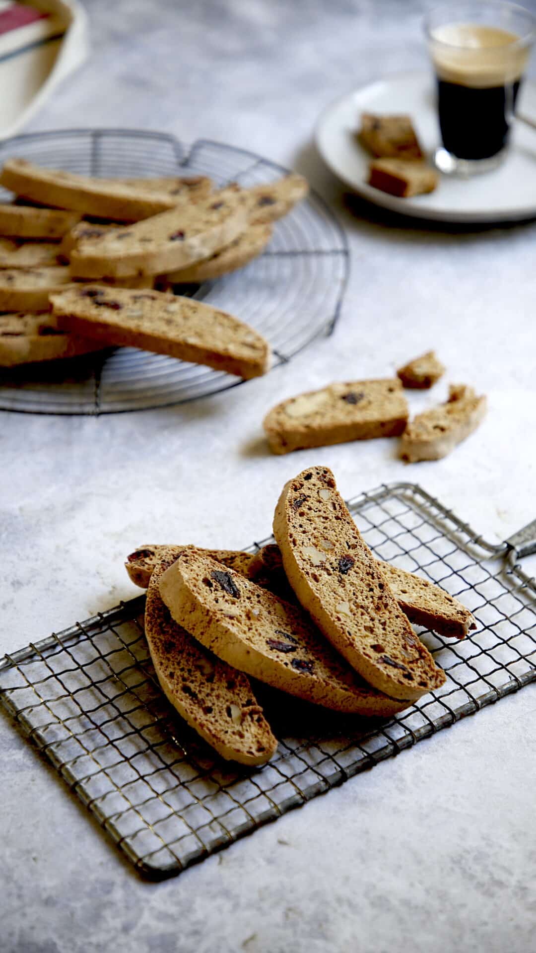 Biscotti cookies on a cooling rack with espresso coffee in the background