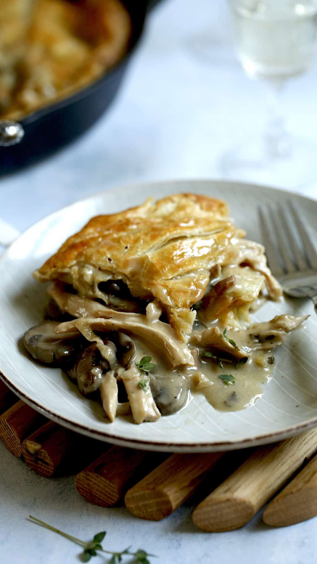 A slice of Chicken and Mushroom Pie on a plate with a fork
