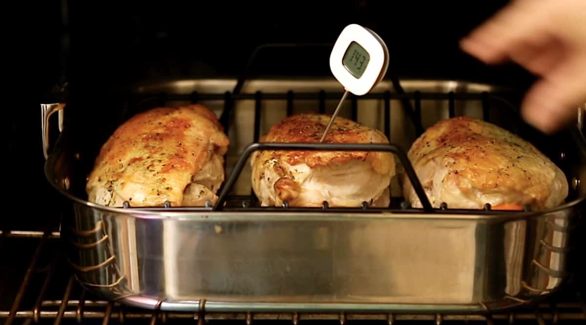 Turkey Breasts roasting in a pan in the oven with a meat thermometer