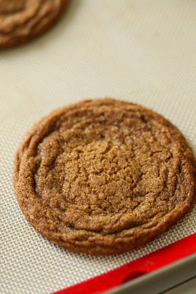 close up shot of a cookie cooling on tray and forming cracks.