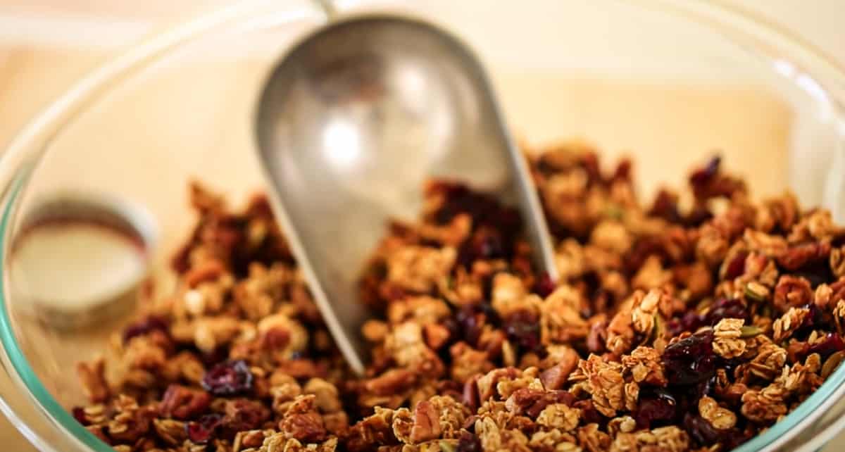 a bowl of freshly baked granola with a scoop
