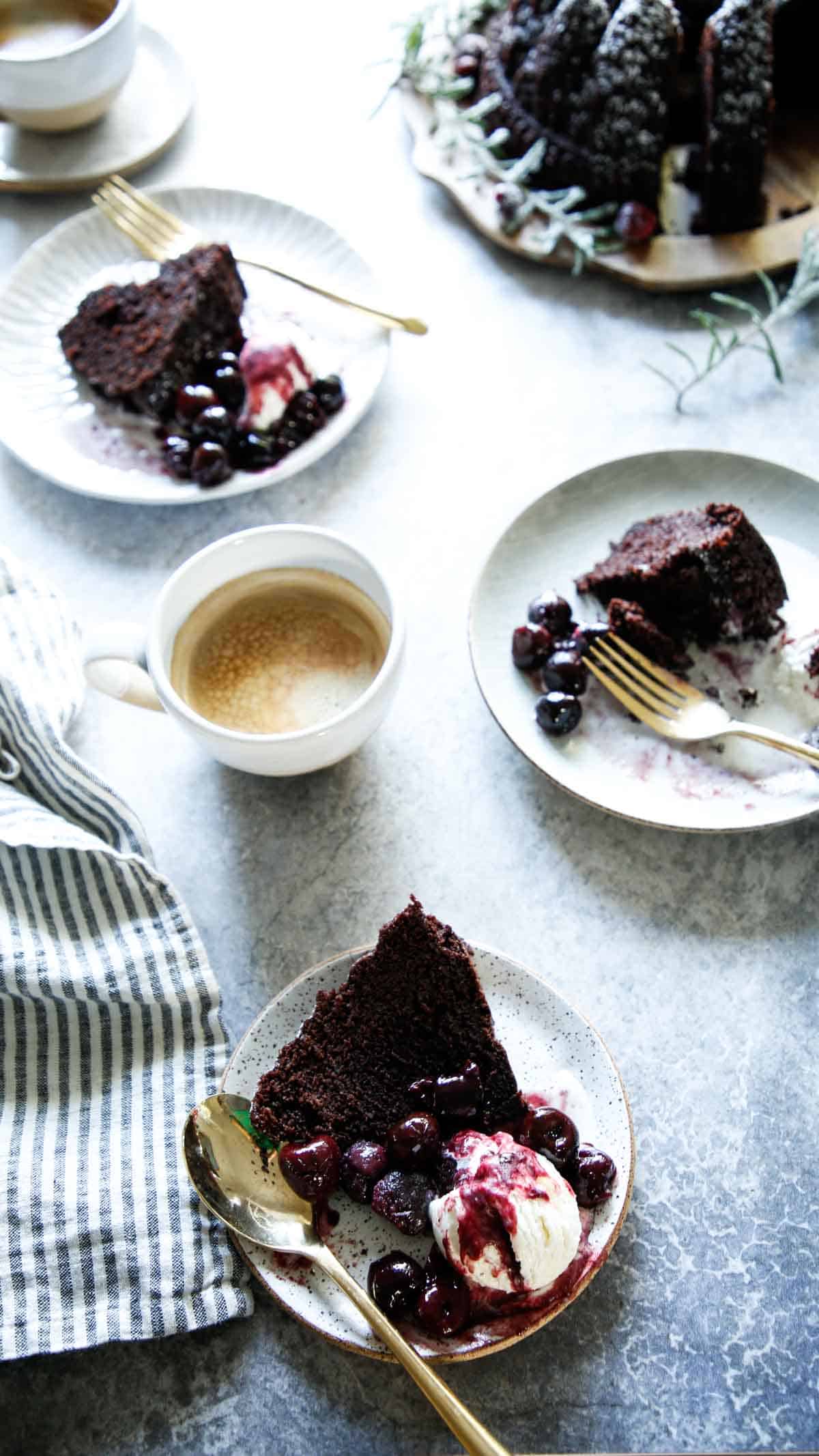 Servings of chocolate cake on plates with coffee cups