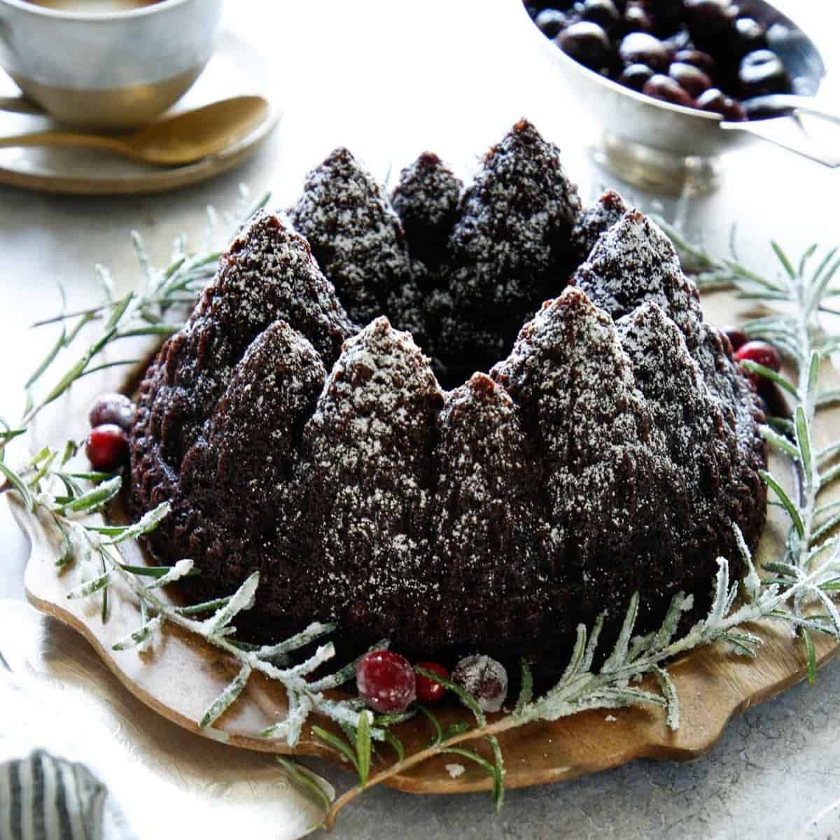 Chocolate Christmas Cake dusted with Powdered Sugar and garnishes with Rosemary Branches