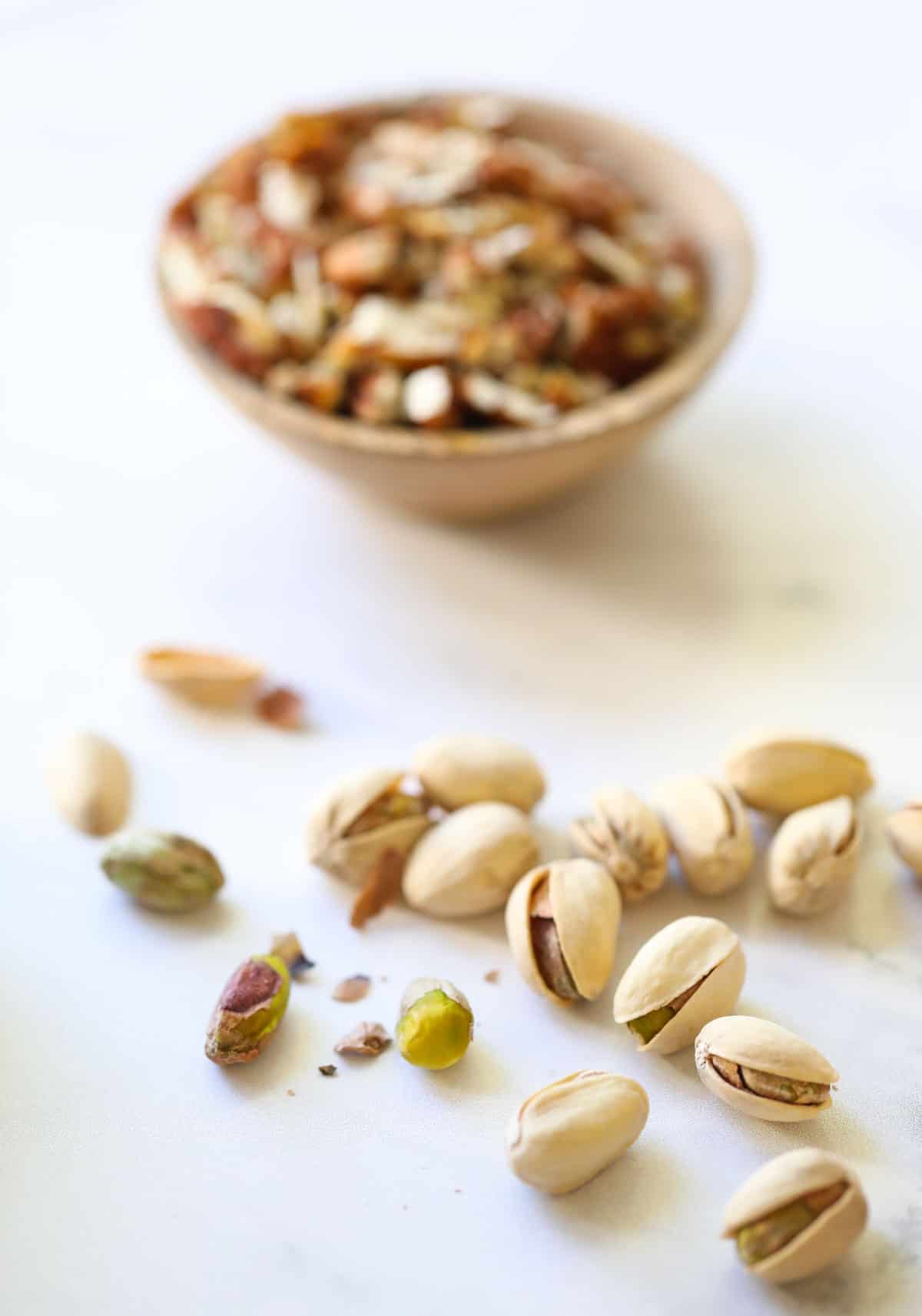 a bowl of chopped pecans and pistachios laid on a counter