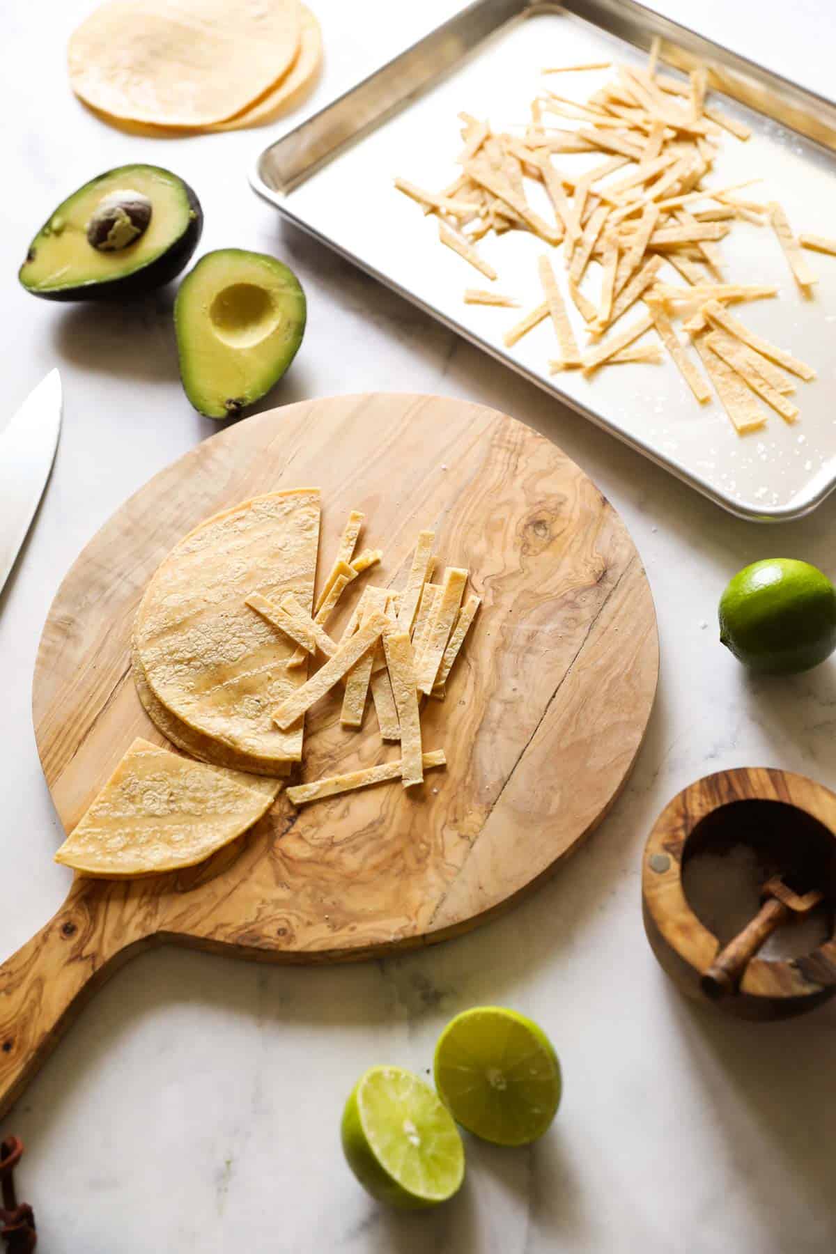Corn tortillas being prepped and sliced and put on a sheet pan