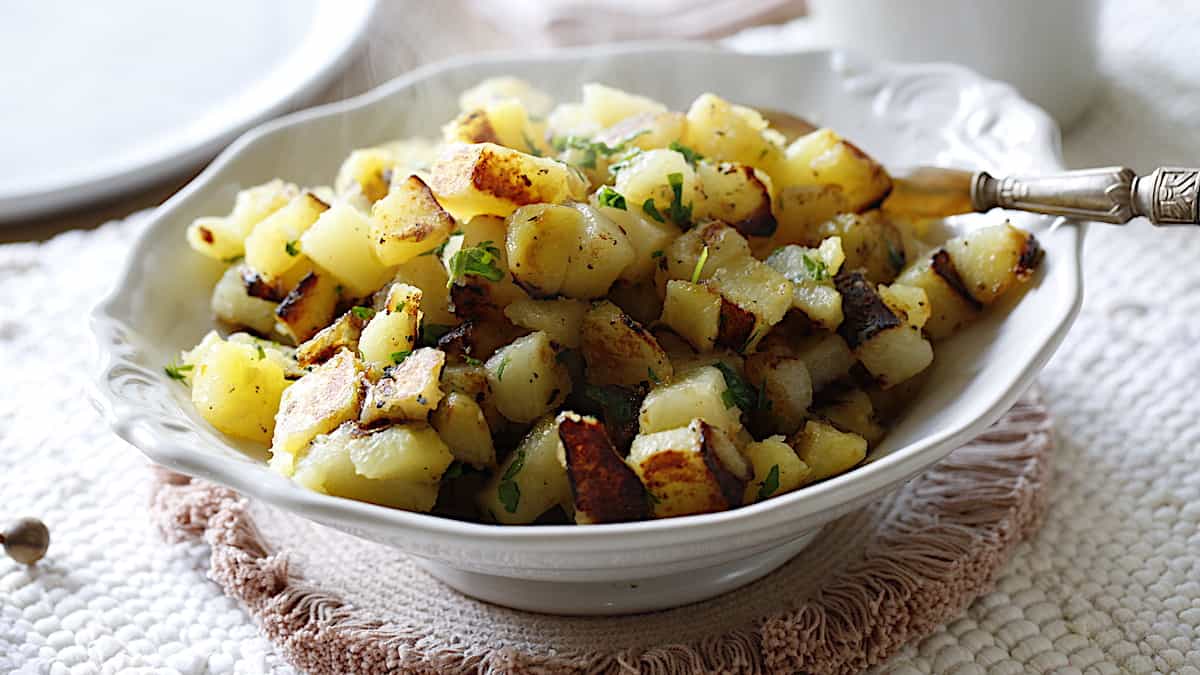 A white bowl filled with crispy homefries