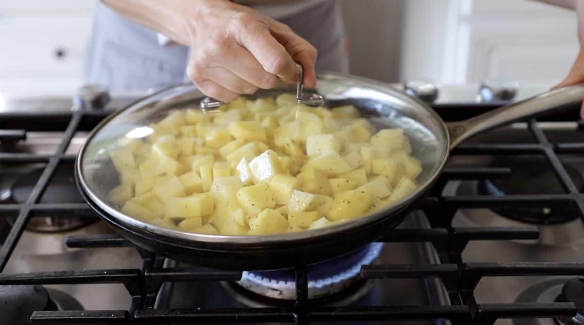 Close up of a skillet covered with homefries in it