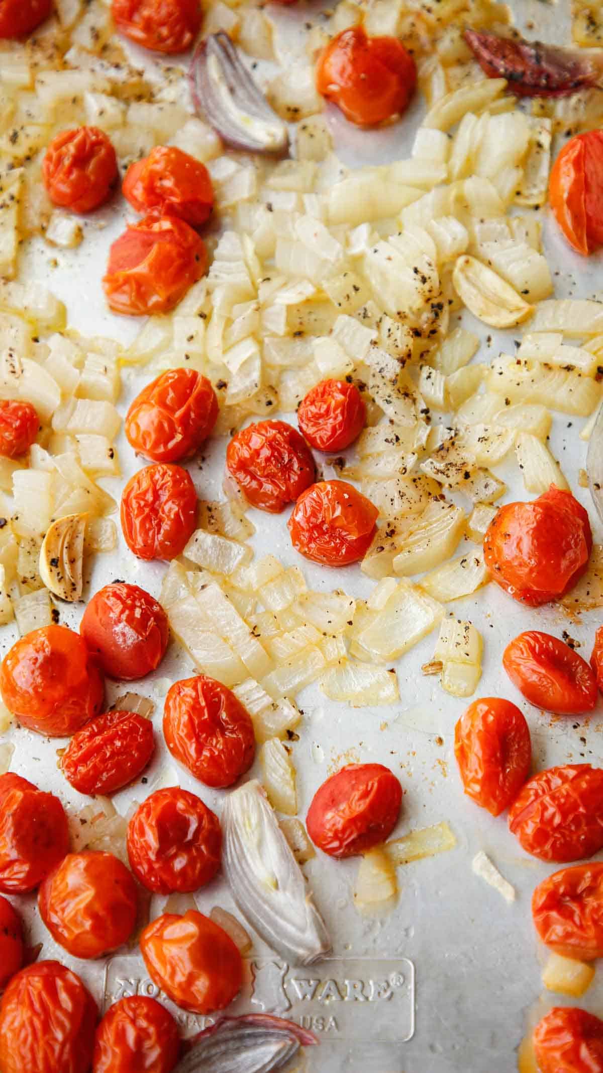 roasted tomatoes onions and shallots on a baking tray