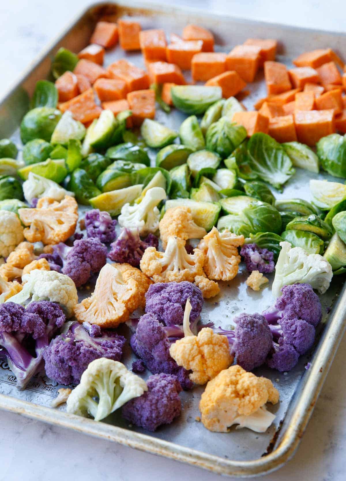 a colorful sheet pan of vegetables ready to be roasted