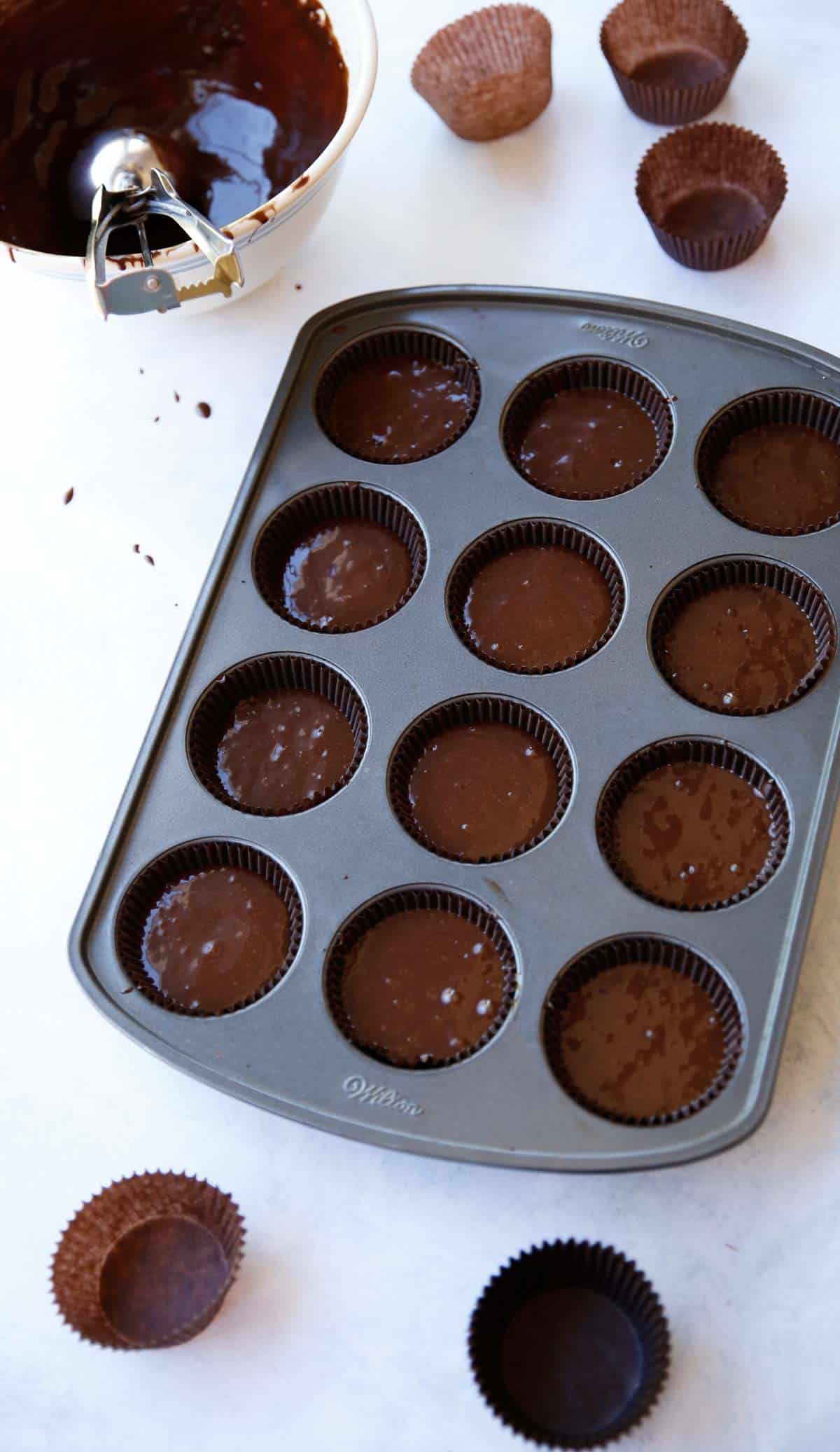 Chocolate cupcake batter in a muffins tin filled ¾ of the way full