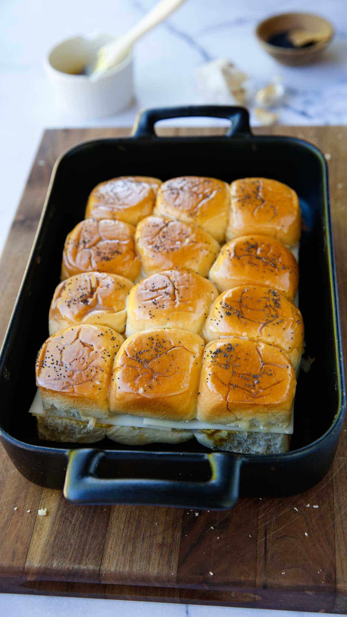 A black casserole dish filled with Ham and hese sliders made with Hawaiian Rolls