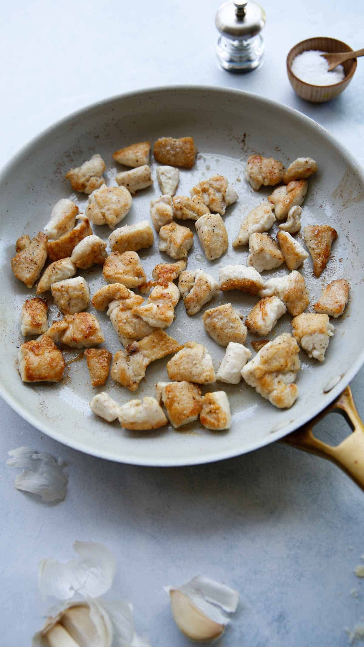Browned chunks of Chicken in a pan
