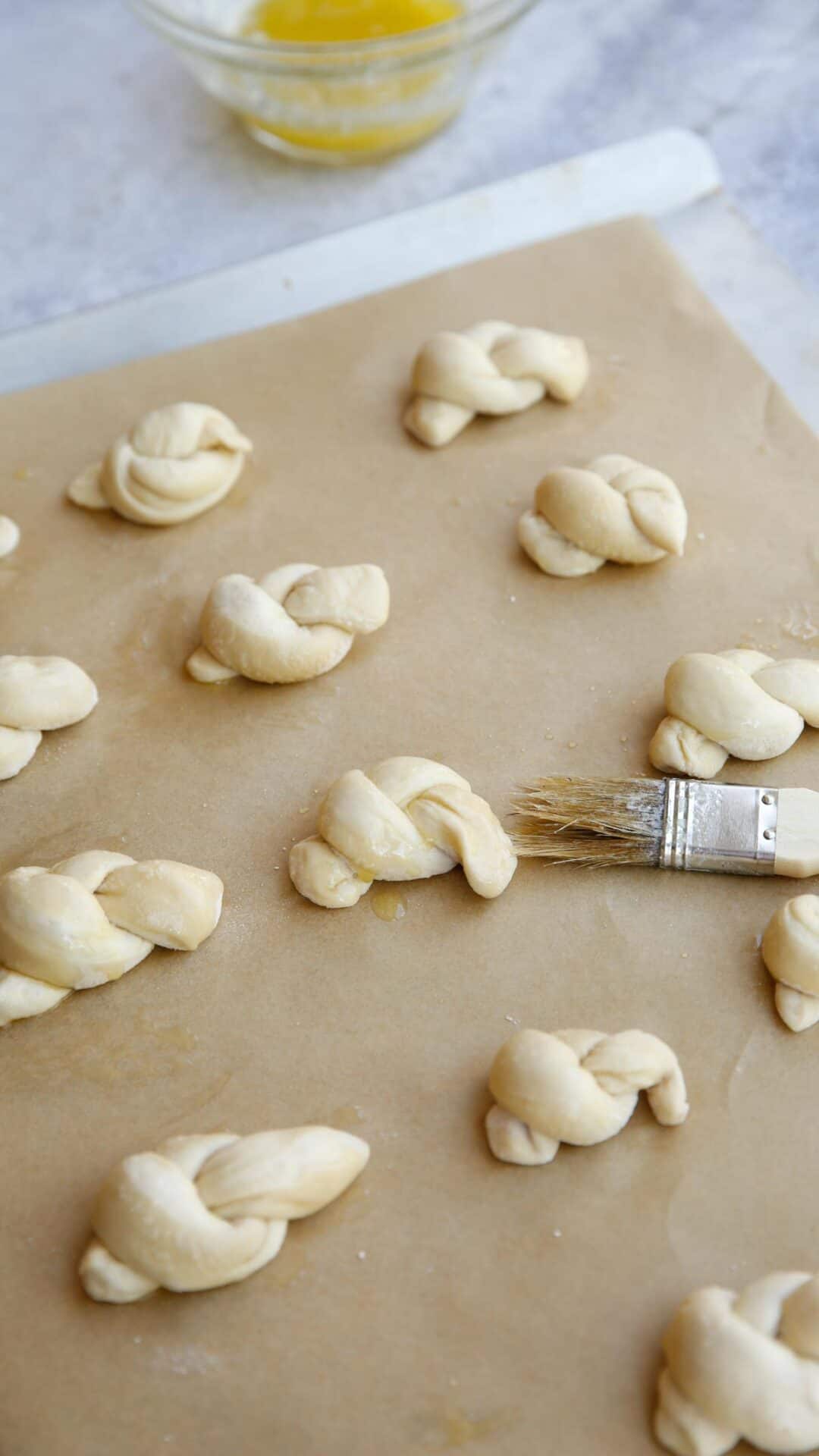 dough knots being brushed with melted butter