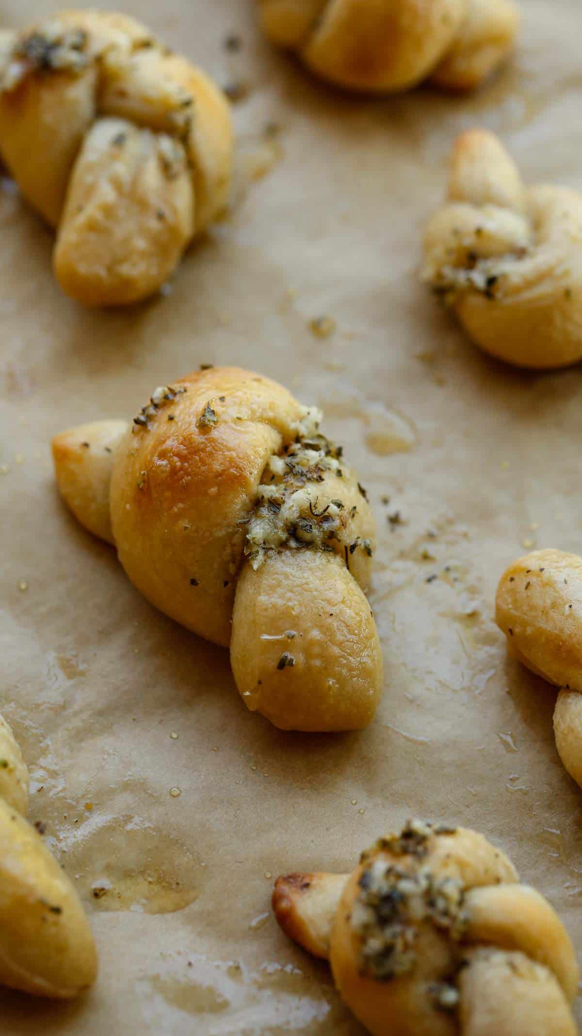 Garlic Knots brushed with melted butter on a sheet pan