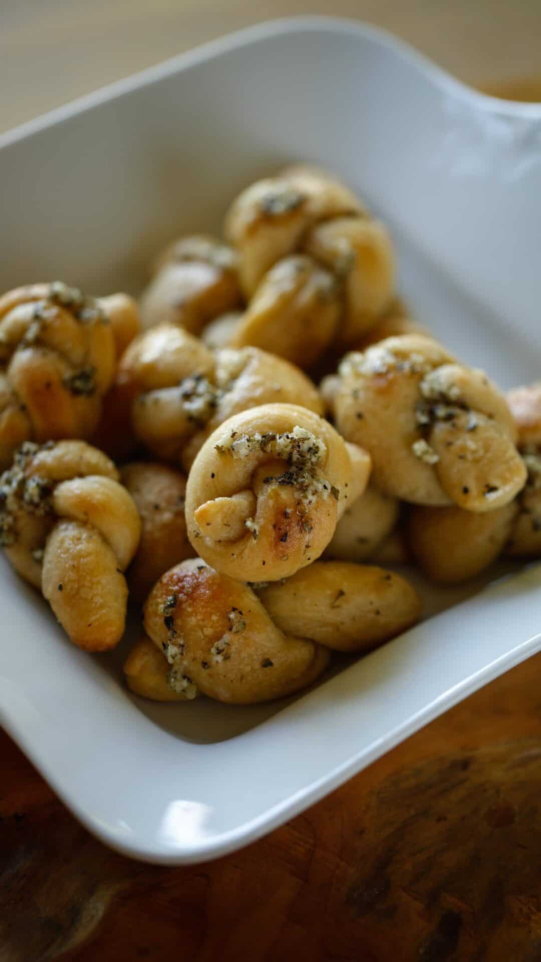 a white platter piled with freshly baked garlic knots