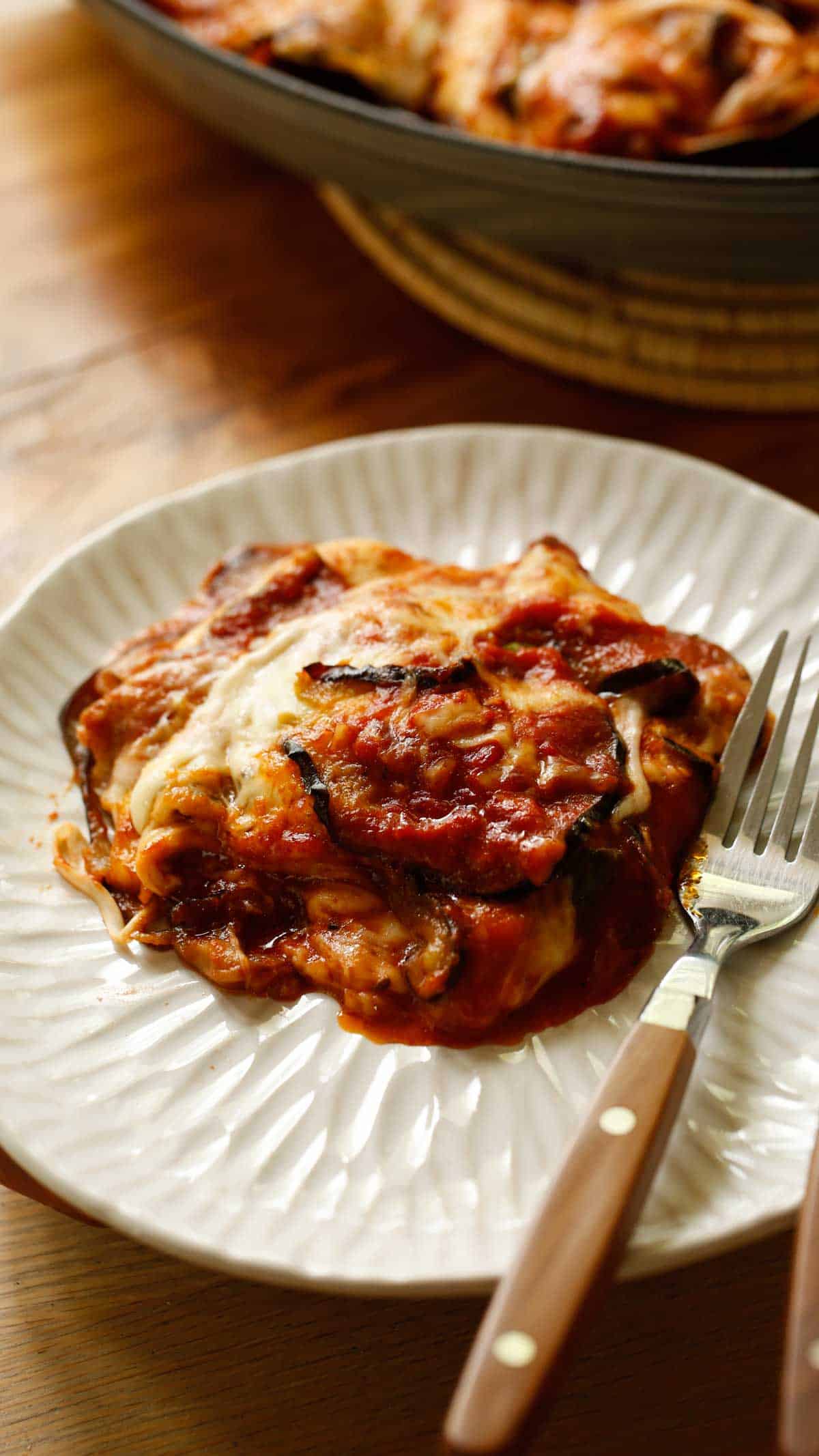 a portion of baked eggplant parmesan on a white plate