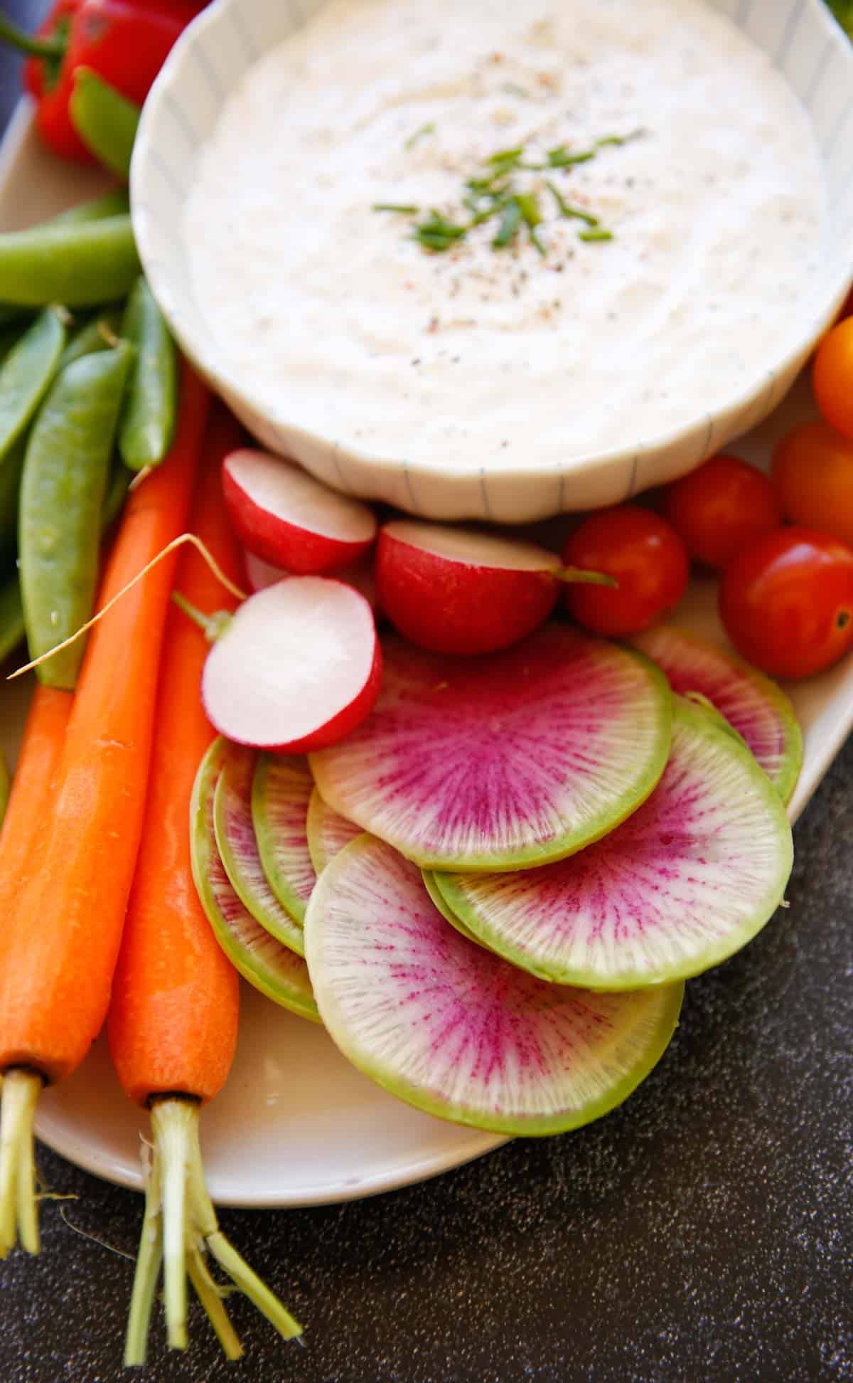 Tight shot watermelon radish and carrots on a platter 