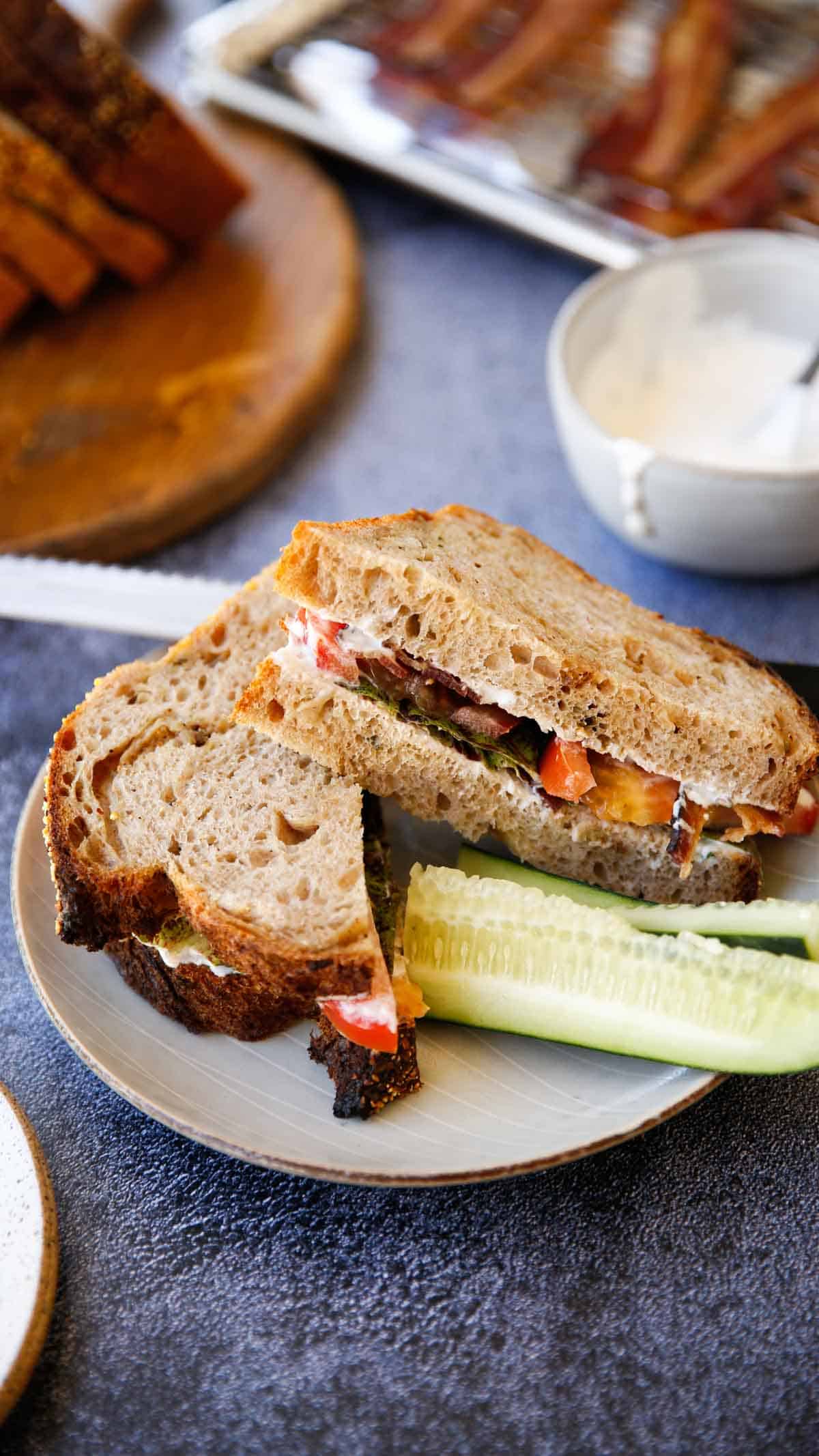 a BLT Sandwich with peppercorn dressing and cucumbers on a plate