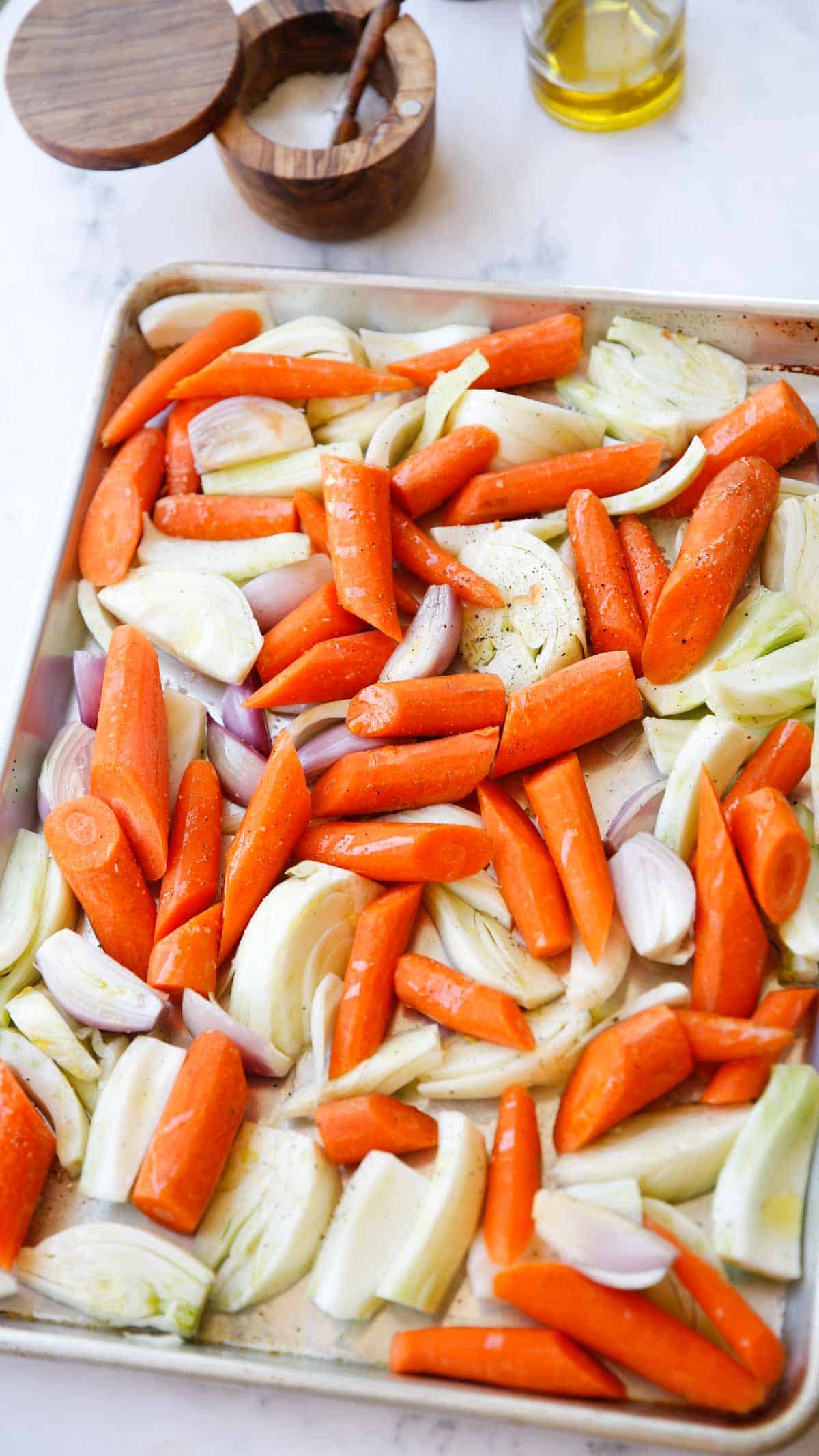 a baking tray loaded with carrots and fennel and shallots