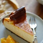 a slice of cheesecake with orange segments on the side