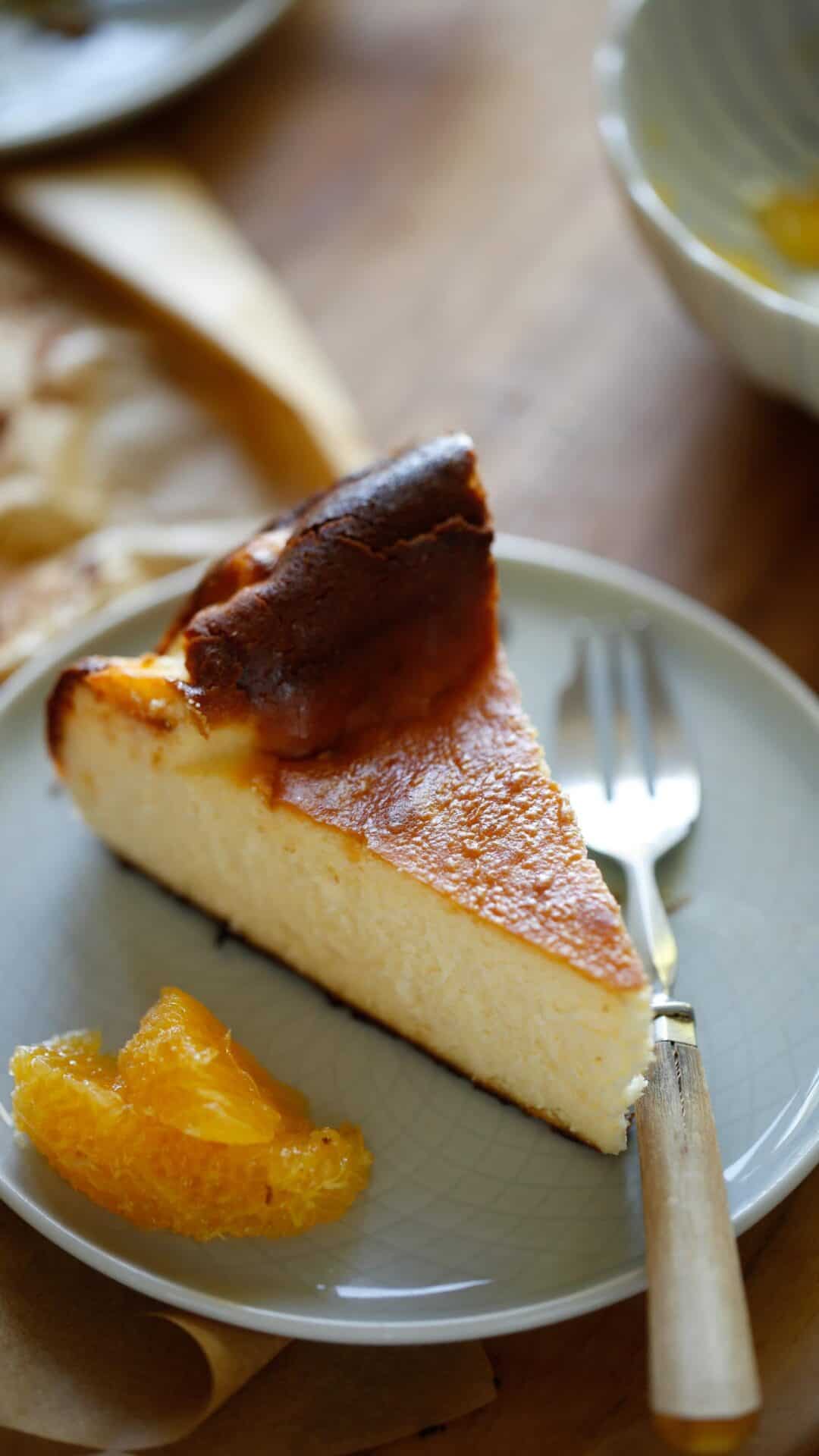 a slice of cheesecake with orange segments on the side