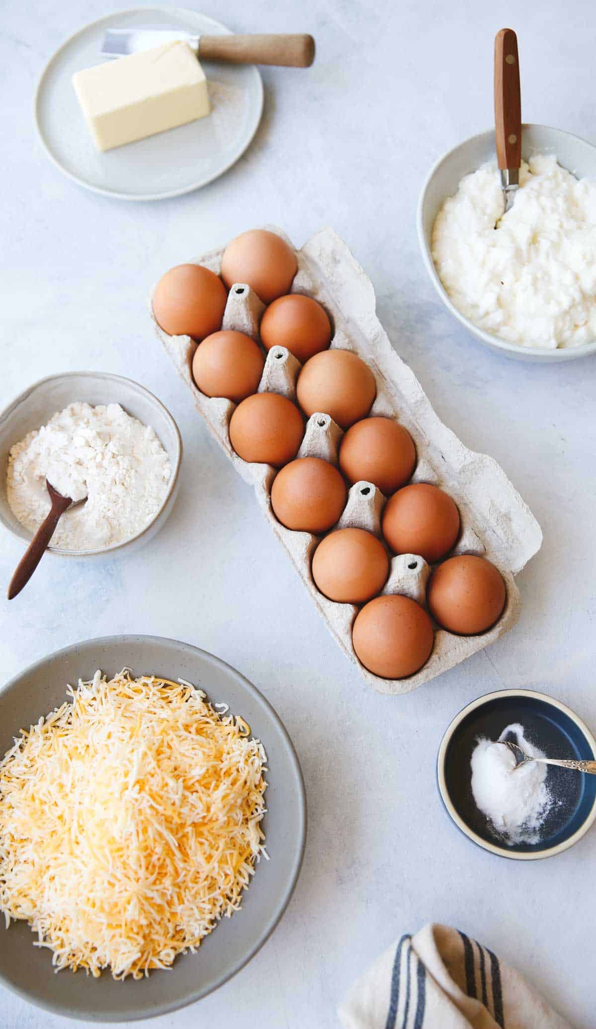 Eggs, Cottage CHeese, CHeddar CHeese, Flour and baking soda on a counter