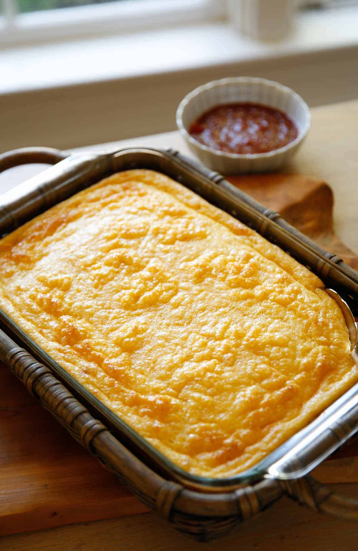 A fully baked Puffy Egg Bake casserole in basket cozy