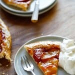 Tart slices on plates with forks and whipped cream