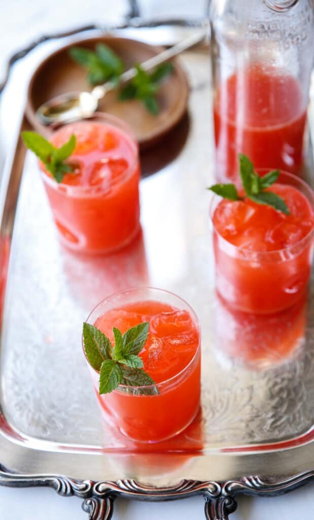 summer drinks on a silver tray with mint garnishes