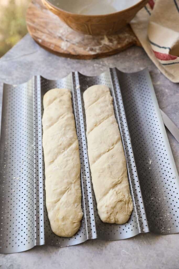 Two logs of dough fitted into a baguette tin