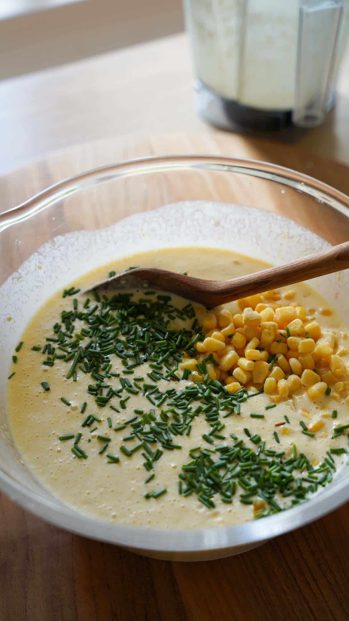 Corn pureed batter with corn kernels on top with chives