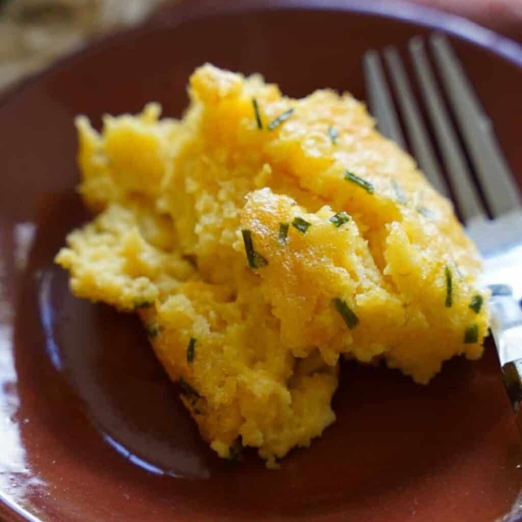 a serving of corn pudding on a plate.