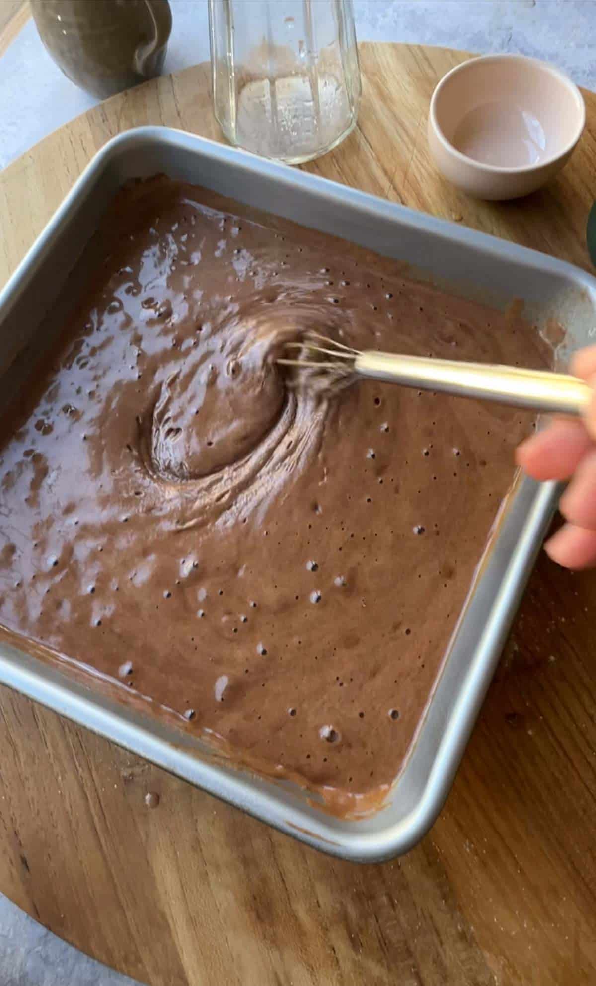 mixing in the vinegar to the cake batter showing the bubbles