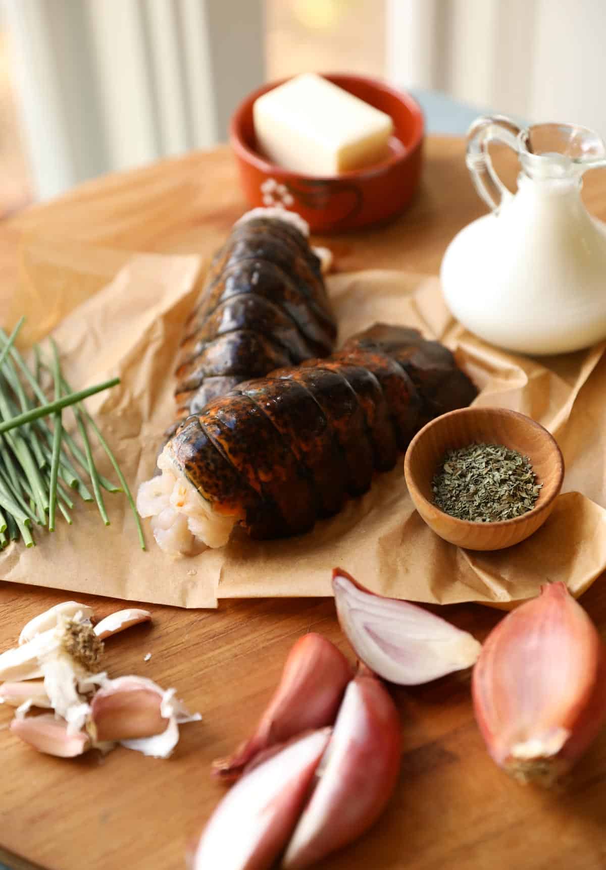 Ingredients laid out around lobster tails for sauce