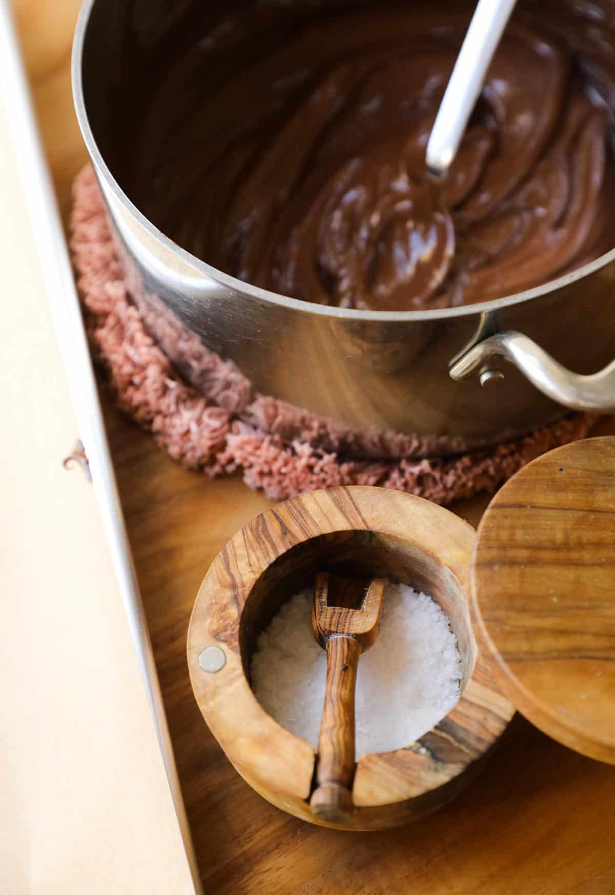 a pot of sea salt and a pan of melted chocolate in the background