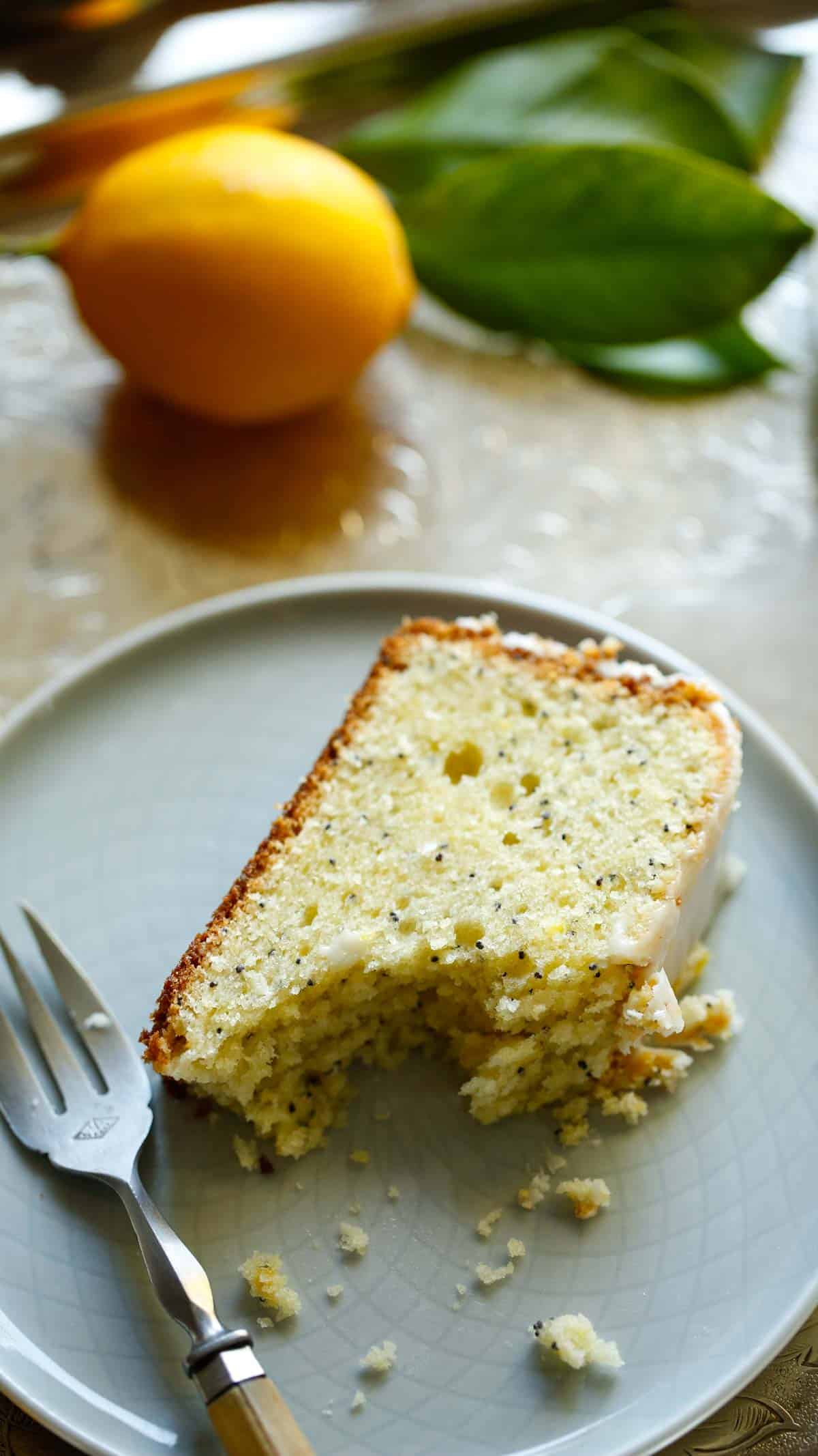 a slice of lemon poppy seed cake on a blue plate