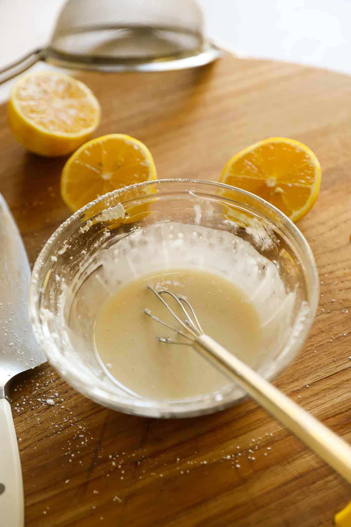 a small bowl of lemon glaze being mixed up