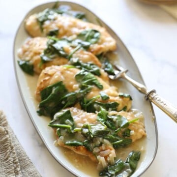 Chicken breasts with creamy wine sauce on a platter
