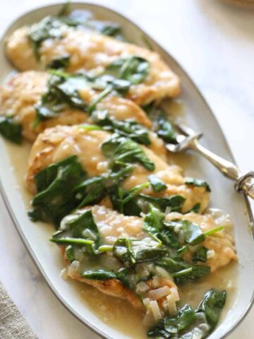 Chicken breasts with creamy wine sauce on a platter