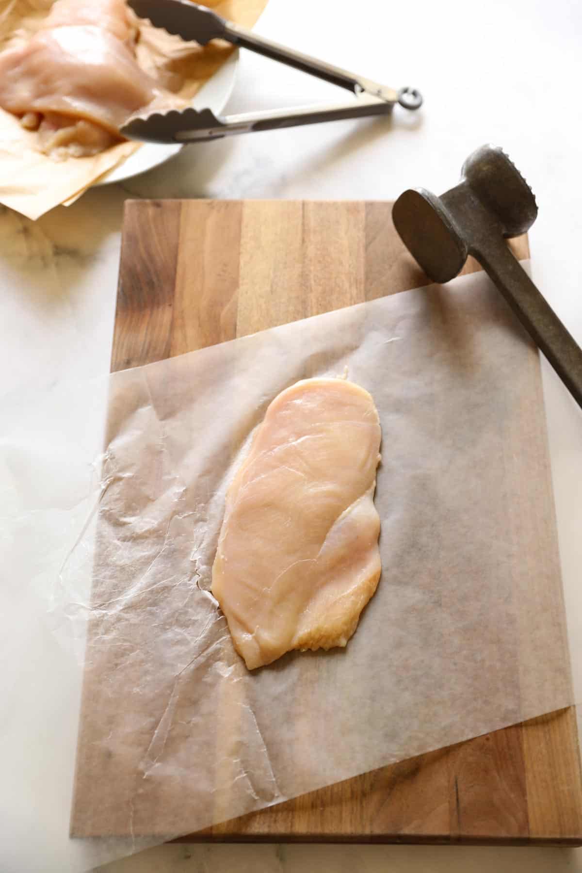 a chicken breast cutlet poubded between wax paper