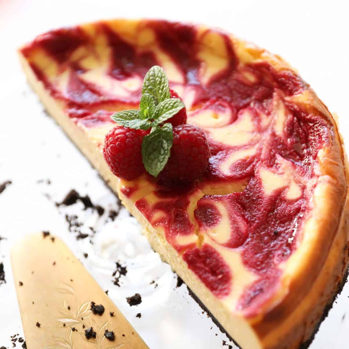 a baked cheesecake with a swirl of raspberry in it on a cakestand