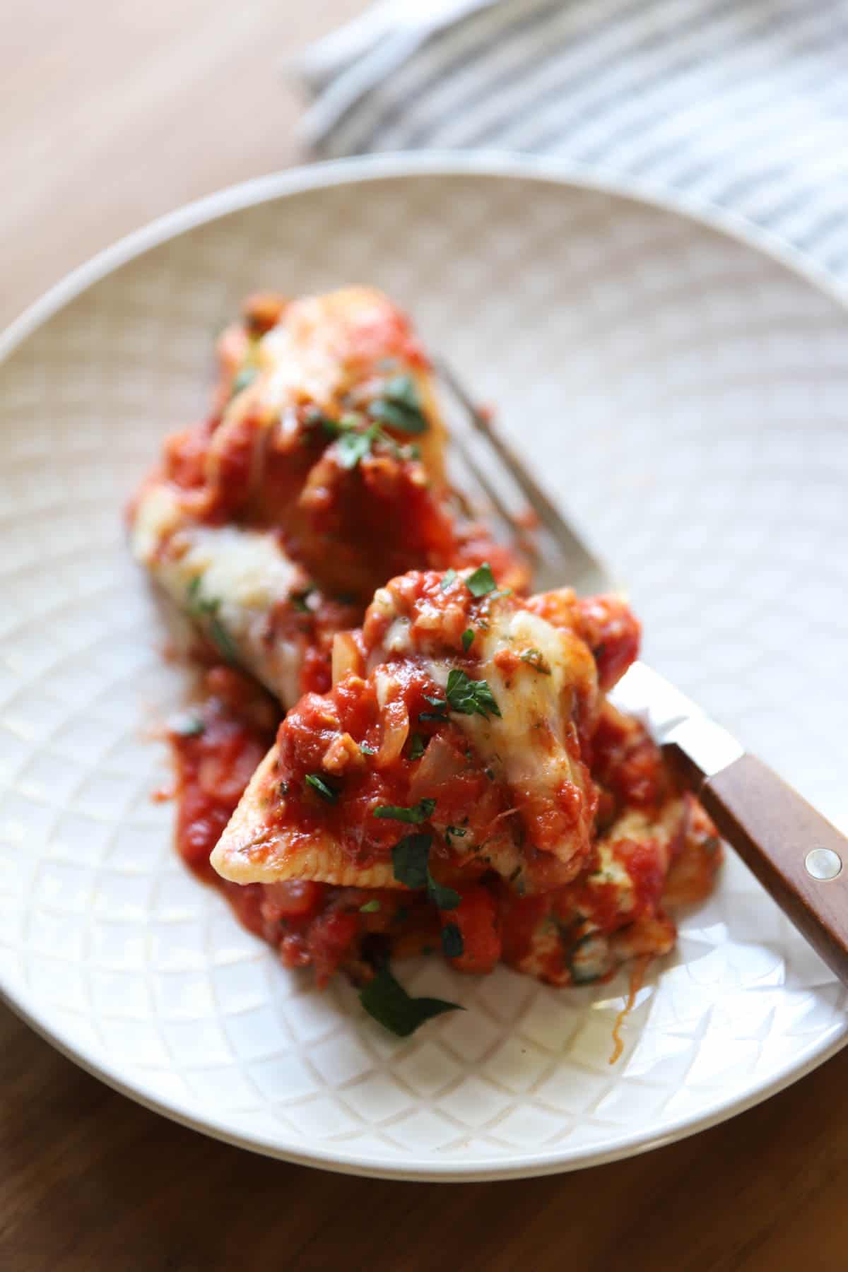 a single serving of baked shells covered with tomato sauce and cheese